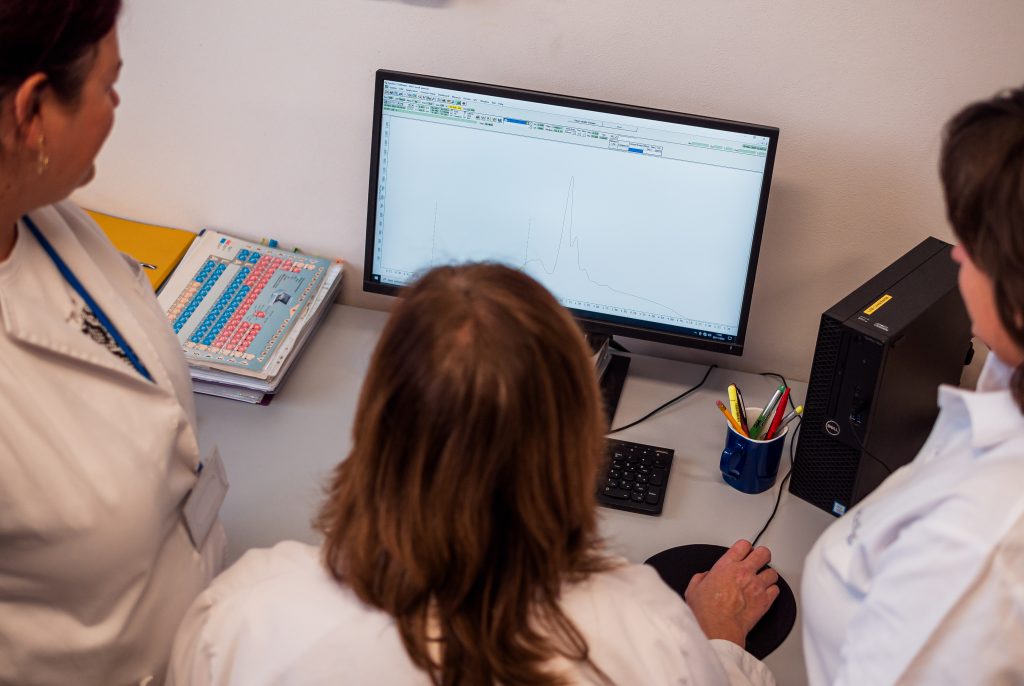 Researchers analyzing data on computer screen.